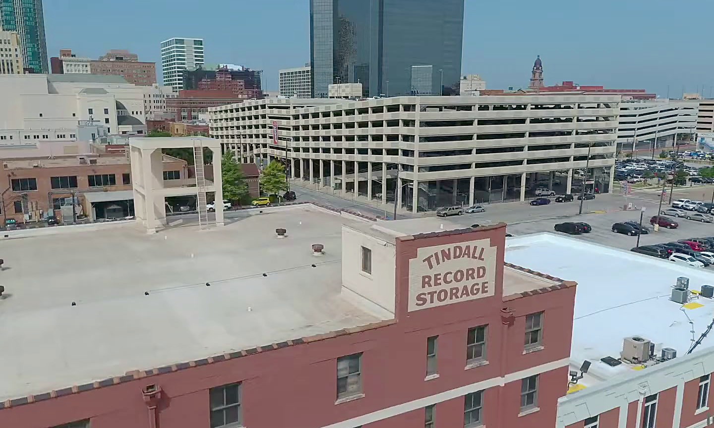 A finished commercial roof on a red brick building with the Fort Worth skyline behind it